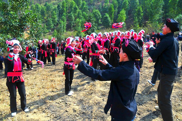 图为田林县当地瑶族群众开展抛沙包民俗文化活动